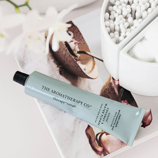 Tube of The Aromatherapy Co product on a magazine with flowers in the background